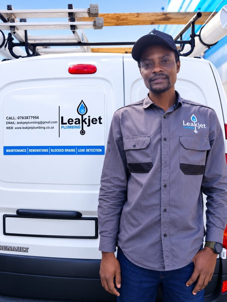 Ronald Mhundwa, founder of Leak Jet Plumbing, in branded uniform beside the company van